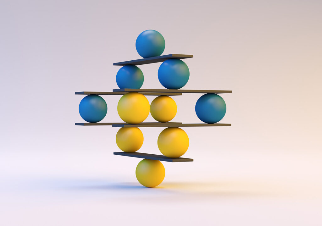 A sculpture of colorful spheres and black planks balancing in a symmetrical tower. Blue and yellow spheres alternate in layers with planks resting between them, creating a structured yet delicate appearance against a soft gradient background.